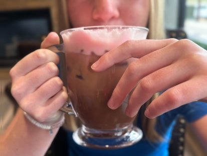 Close up of a satisified customer holding their coffee